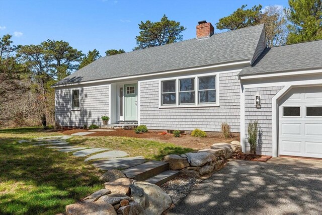 30 Grannys Ln, Orleans, MA 02653 - view of front of property with a front yard, a chimney, a garage, and roof with shingles