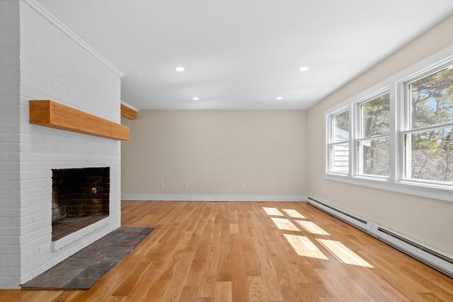 30 Grannys Ln, Orleans, MA 02653 - unfurnished living room with baseboard heating, light wood-style floors, a brick fireplace, and plenty of natural light
