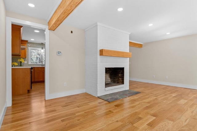 30 Grannys Ln, Orleans, MA 02653 - unfurnished living room with a brick fireplace, baseboards, beam ceiling, and light wood-style floors