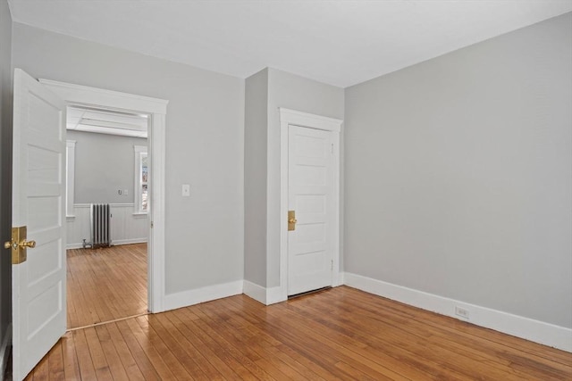 spare room with hardwood / wood-style flooring and radiator