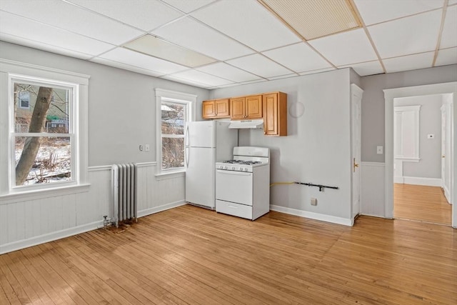 kitchen featuring a drop ceiling, white appliances, radiator heating unit, and light hardwood / wood-style floors