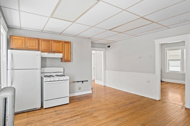 kitchen with a drop ceiling, white appliances, and light hardwood / wood-style floors