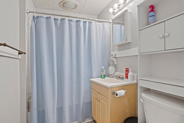 bathroom featuring vanity, walk in shower, and toilet