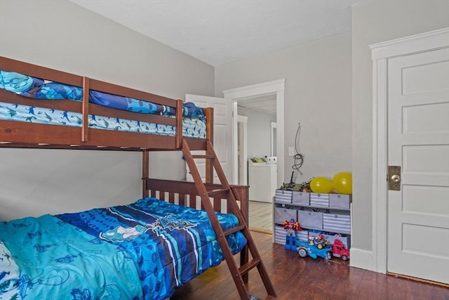 bedroom featuring washer / dryer and dark wood-type flooring