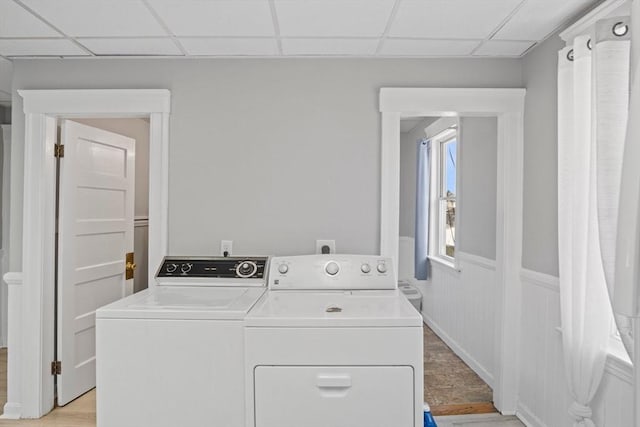 clothes washing area with washer and clothes dryer and light hardwood / wood-style flooring