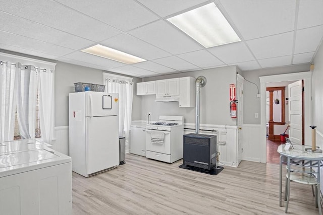 kitchen featuring washer / dryer, white cabinetry, a paneled ceiling, white appliances, and light hardwood / wood-style floors