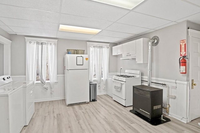 kitchen with white appliances, light hardwood / wood-style flooring, a paneled ceiling, independent washer and dryer, and white cabinets