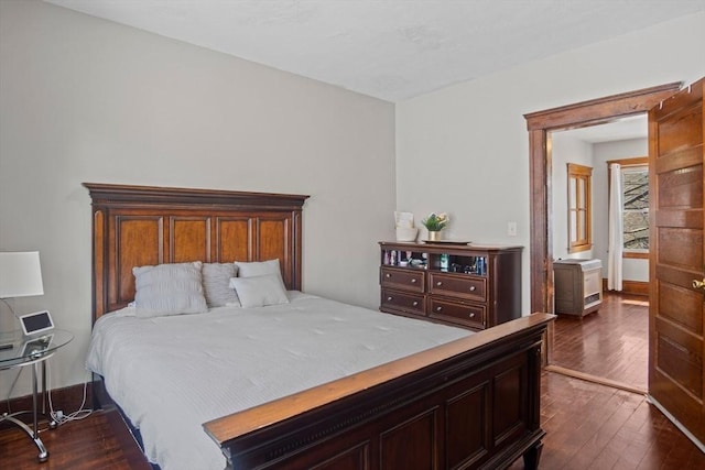 bedroom with dark hardwood / wood-style floors