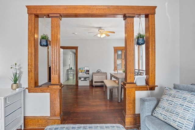 interior space with decorative columns, dark wood-type flooring, and ceiling fan