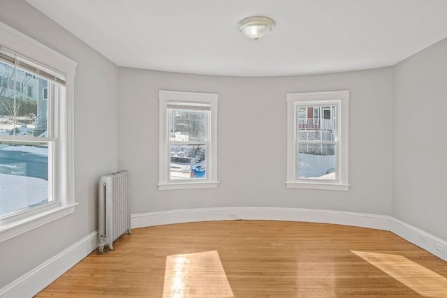 spare room with radiator and light hardwood / wood-style floors