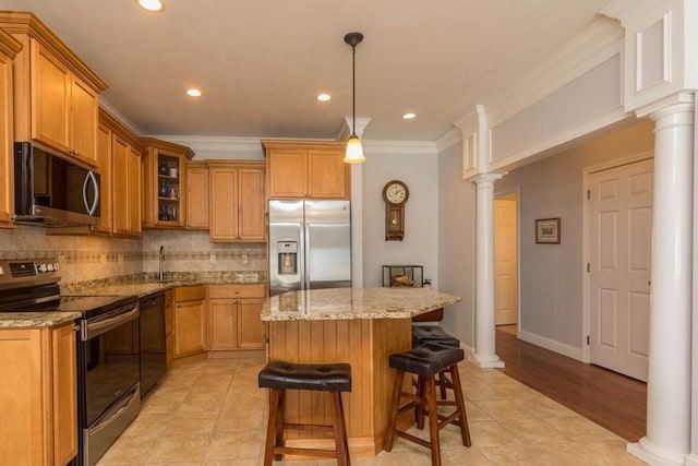 kitchen featuring ornamental molding, stainless steel appliances, a center island, and ornate columns