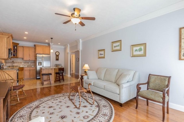 living room with sink, light hardwood / wood-style flooring, ornamental molding, and ceiling fan