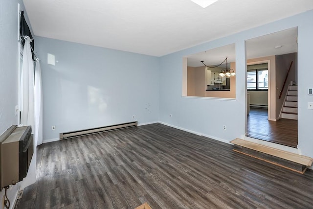 spare room featuring a chandelier, dark hardwood / wood-style flooring, and a baseboard heating unit