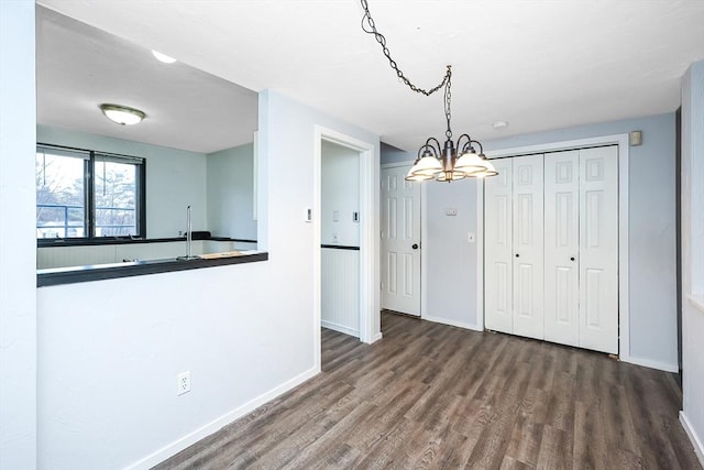 unfurnished dining area with hardwood / wood-style flooring and a notable chandelier