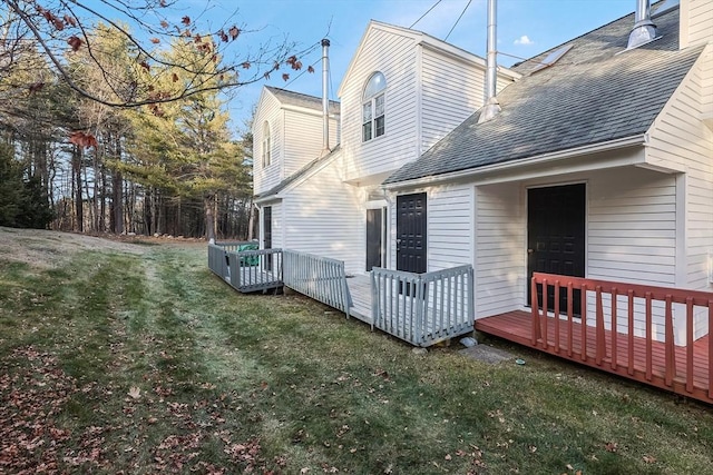 back of house with a lawn and a deck