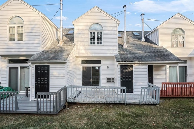 rear view of property with a wooden deck and a yard