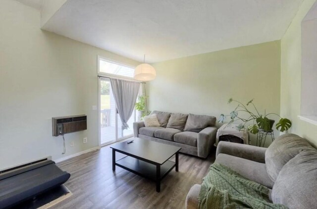 living room with hardwood / wood-style floors, a baseboard radiator, and a wall mounted AC