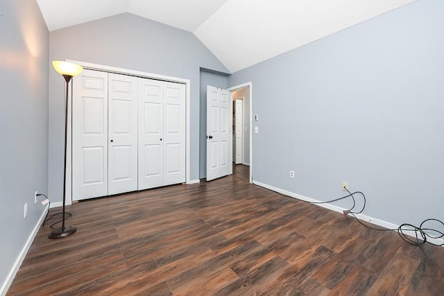 unfurnished bedroom featuring a closet, dark hardwood / wood-style flooring, and lofted ceiling