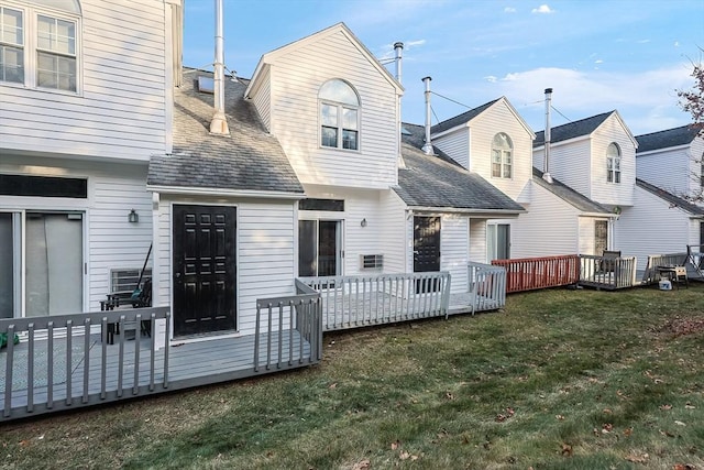 back of property featuring a deck and a yard