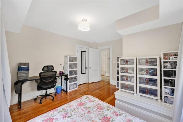 bedroom with baseboards and wood finished floors