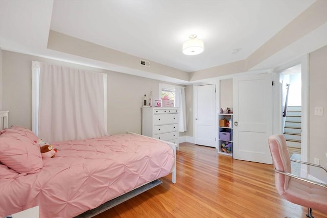 bedroom with light wood-type flooring and visible vents
