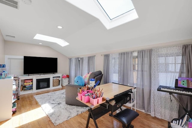 living area featuring recessed lighting, visible vents, wood finished floors, and vaulted ceiling with skylight