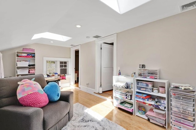 playroom with visible vents, recessed lighting, lofted ceiling with skylight, and wood finished floors