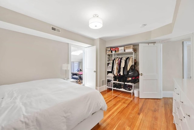 bedroom featuring a closet, light wood-type flooring, and visible vents