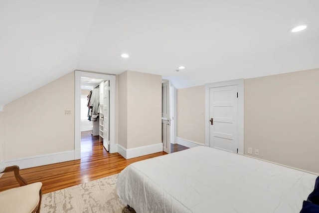 bedroom with recessed lighting, baseboards, wood finished floors, and vaulted ceiling