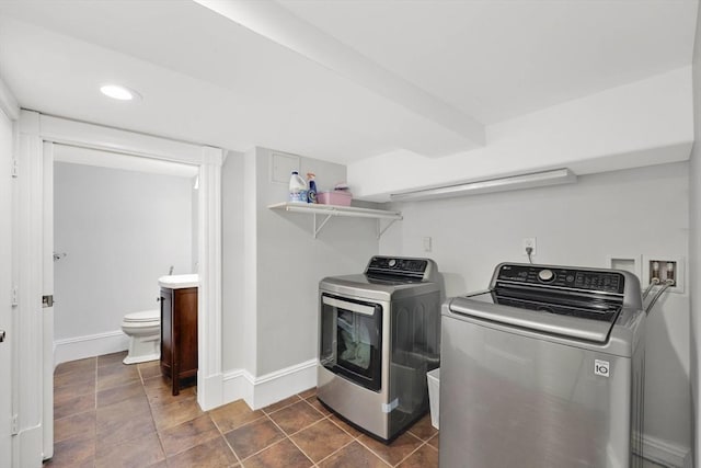 clothes washing area featuring baseboards, recessed lighting, and washing machine and clothes dryer
