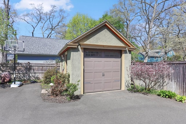 garage featuring fence and driveway