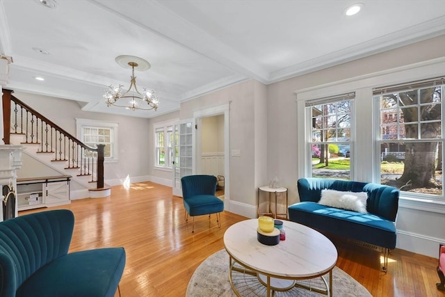 living room with an inviting chandelier, beam ceiling, baseboards, light wood-style floors, and stairway
