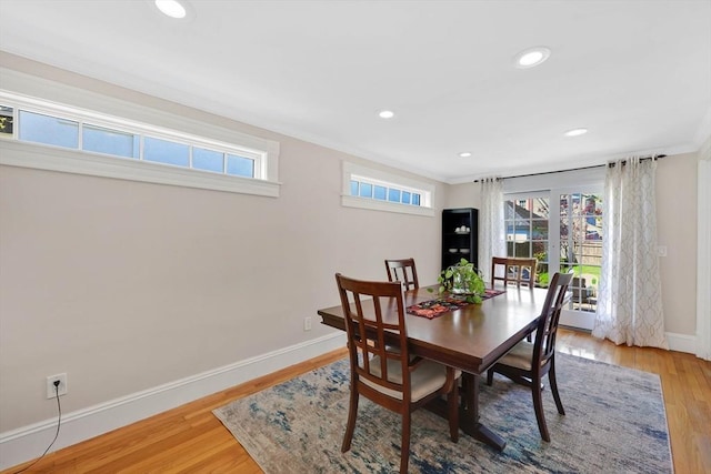 dining space with crown molding, baseboards, a wealth of natural light, and wood finished floors