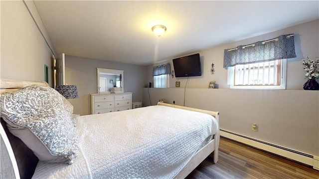 bedroom with baseboard heating and dark hardwood / wood-style flooring