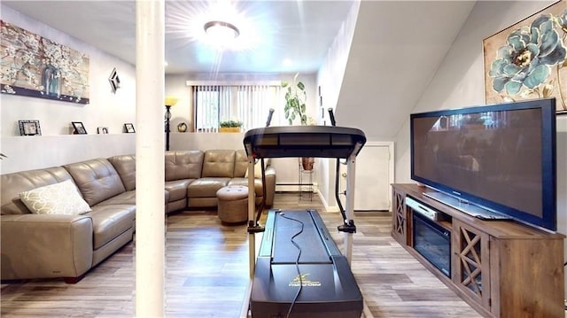 living room featuring light wood-type flooring and a baseboard heating unit