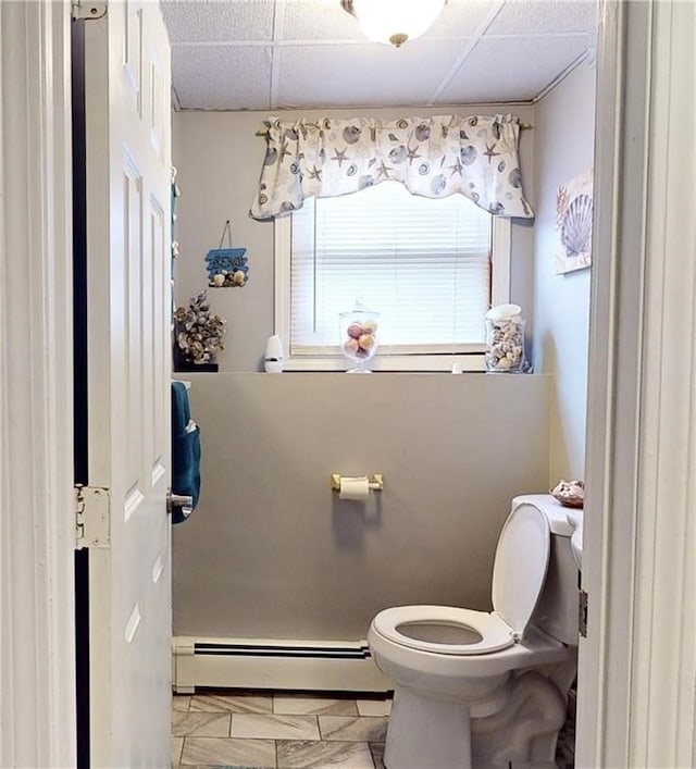 bathroom with a paneled ceiling, a baseboard radiator, and toilet