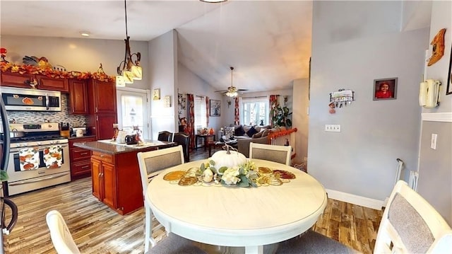 dining area featuring a wealth of natural light, ceiling fan, light hardwood / wood-style floors, and high vaulted ceiling