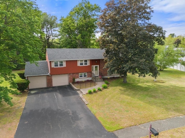 3 Biggar Ave, Wilmington, MA 01887 - split foyer home with asphalt driveway, a front yard, brick siding, and an attached garage