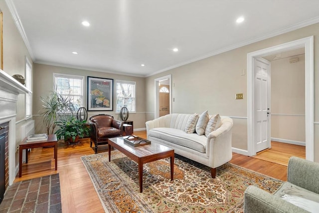 living area featuring a fireplace with flush hearth, wood finished floors, recessed lighting, crown molding, and baseboards