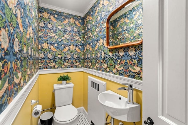 bathroom featuring toilet, a sink, radiator, wainscoting, and crown molding