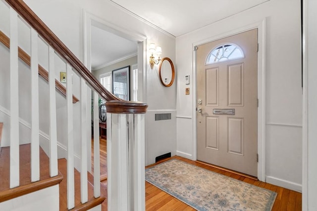 entrance foyer featuring ornamental molding, stairs, baseboards, and wood finished floors