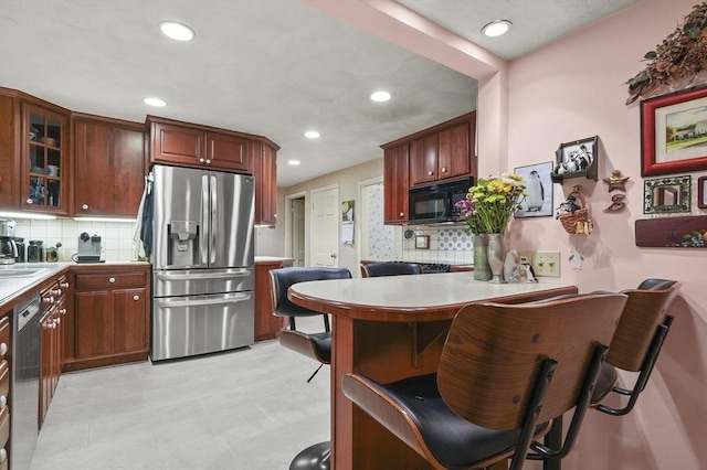 3 Tory Dr, Shrewsbury, MA 01545 - kitchen with appliances with stainless steel finishes, light countertops, backsplash, a peninsula, and glass insert cabinets