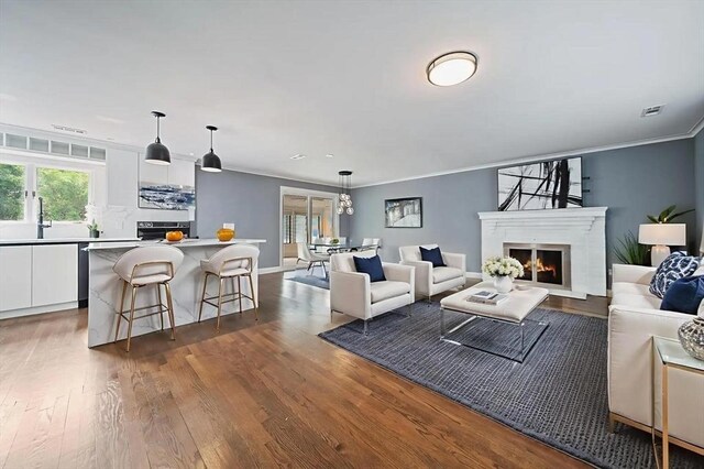123 Walnut St, Saugus, MA 01906 - living area with ornamental molding, wood finished floors, and a warm lit fireplace