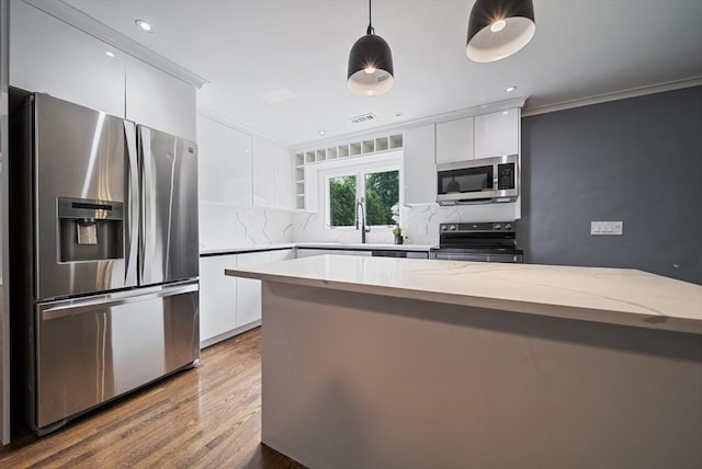 123 Walnut St, Saugus, MA 01906 - kitchen featuring stainless steel appliances, modern cabinets, backsplash, white cabinets, and crown molding