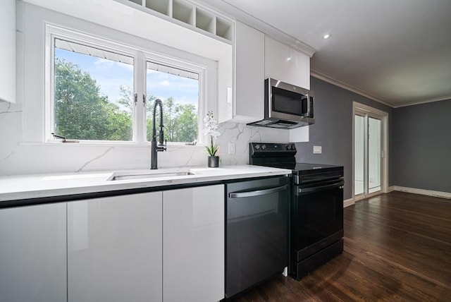 123 Walnut St, Saugus, MA 01906 - kitchen featuring appliances with stainless steel finishes, white cabinets, dark wood-style floors, healthy amount of natural light, and ornamental molding