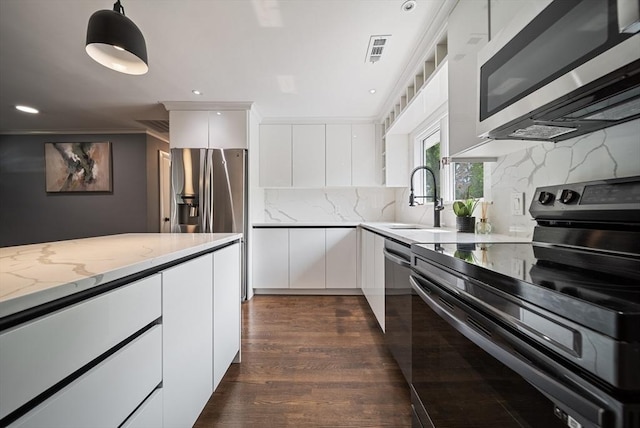 123 Walnut St, Saugus, MA 01906 - kitchen featuring stainless steel appliances, white cabinetry, light stone counters, decorative backsplash, and recessed lighting