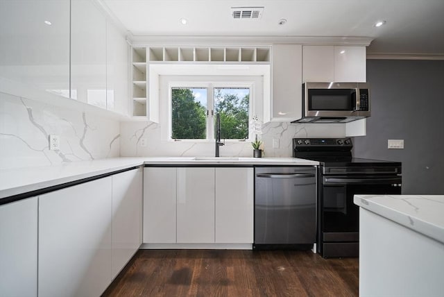 123 Walnut St, Saugus, MA 01906 - kitchen featuring appliances with stainless steel finishes, white cabinets, dark wood finished floors, modern cabinets, and recessed lighting