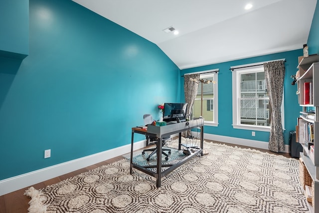 home office with lofted ceiling, baseboards, visible vents, and wood finished floors