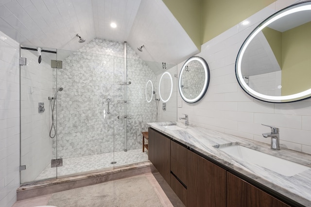 bathroom with a stall shower, a sink, and tile walls