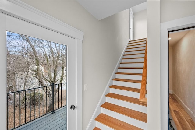 staircase with baseboards and wood finished floors